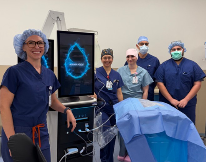 Surgical team standing beside operating equipment