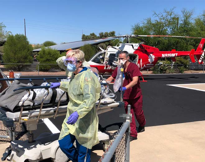 Medical team transporting patient near helicopter