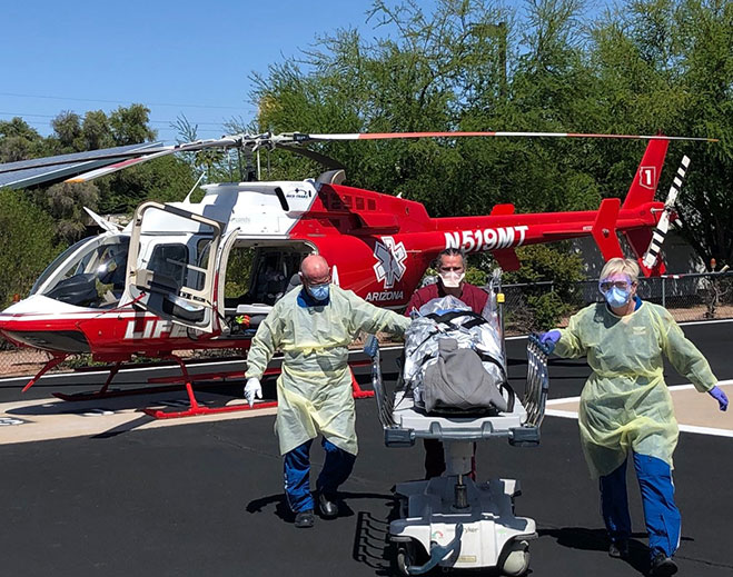 Medical team transporting patient near helicopter