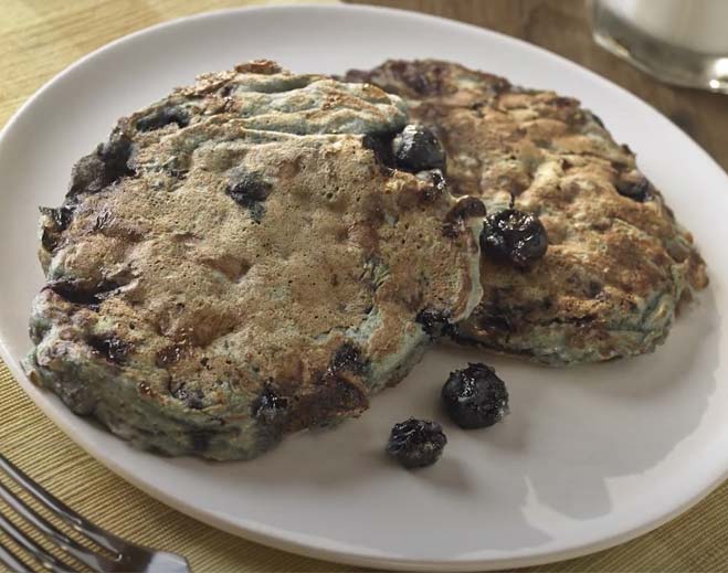 Blueberry pancakes on white plate