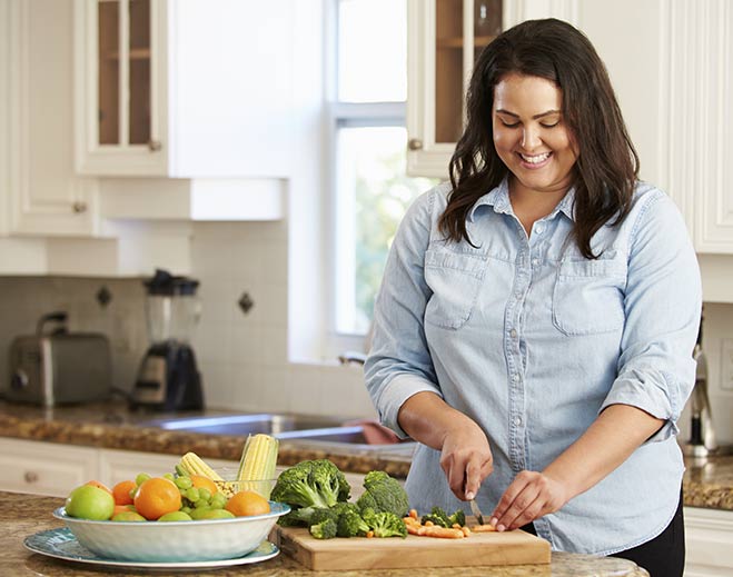 Woman preparing fresh vegetables in kitchen