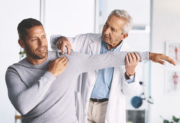 Doctor assisting patient with arm movement